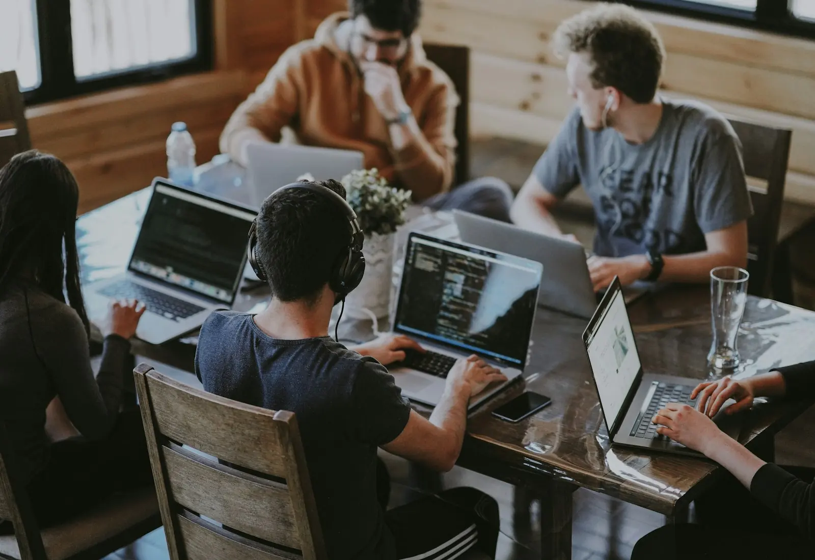 A small team working on laptops around a shared table