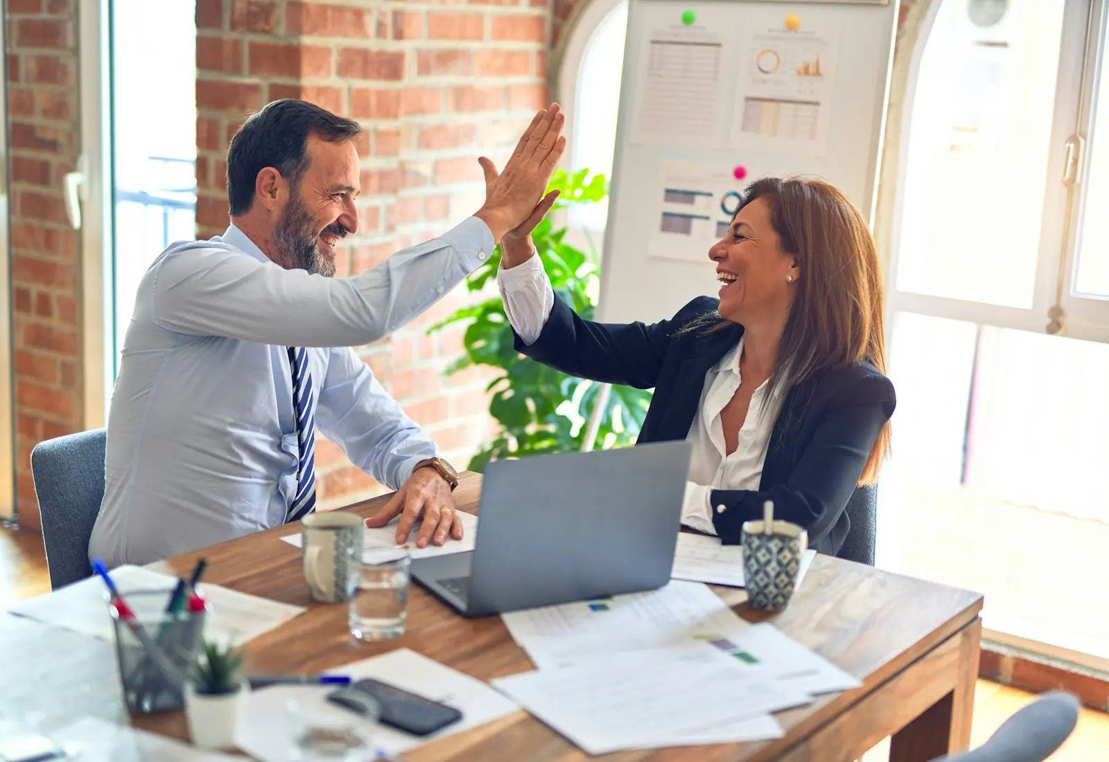 Two business partners reviewing plans together at a laptop