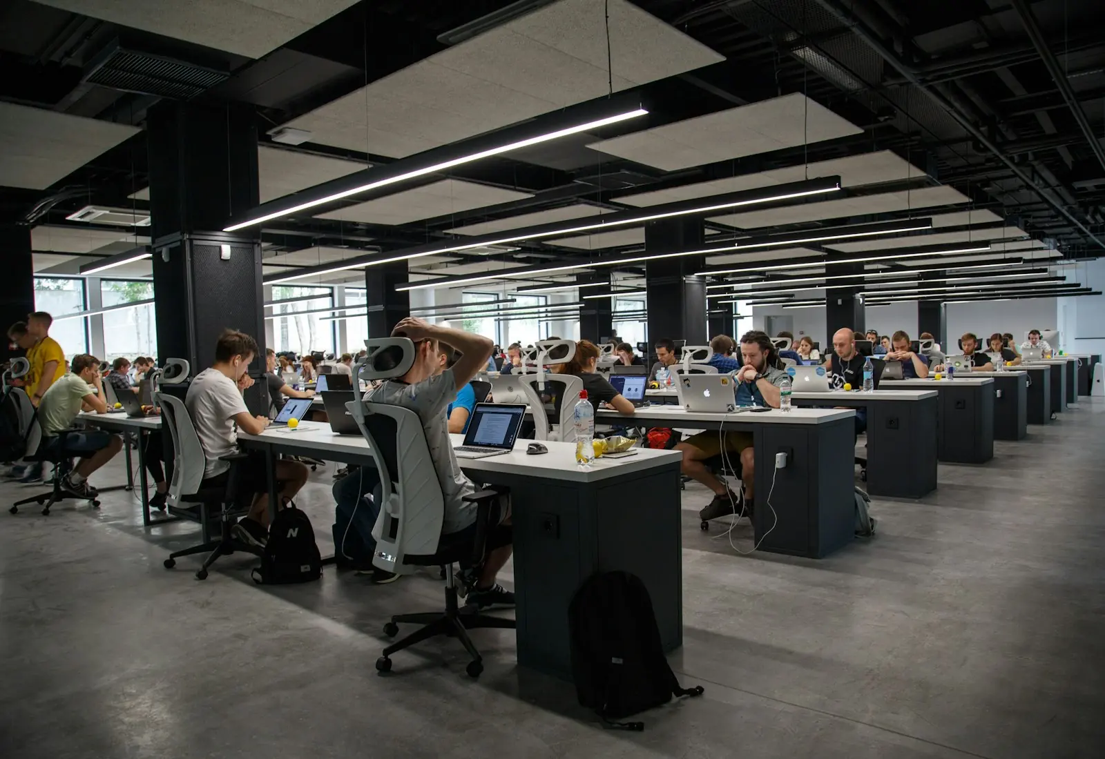 People working at laptops across a large open office